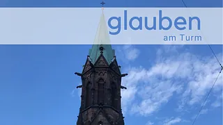 Kirchturmspitze der Ev. Kirche vor blauem Himmel