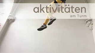 Im Kirchturm seilt sich ein Mensch mit gelber Hose ab
